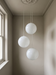 Staircase pendant light trio cascading down a period stairwell – white swirl BO-HA Kaja globes.
