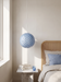 Bedroom pendant light hanging beside a cane headboard and marble nightstand – blue BO-HA Kaja.
