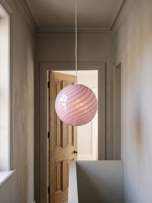 Hallway pendant light hanging in a period apartment corridor, the pink swirl BO-HA Kaja globe.