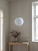 Hanging globe light above an entry console in a panelled hall – the white BO-HA Kaja swirl globe.
