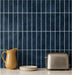Ebba peel and stick backsplash in Lakewater Blue behind a kitchen counter with a mustard jug and a toaster