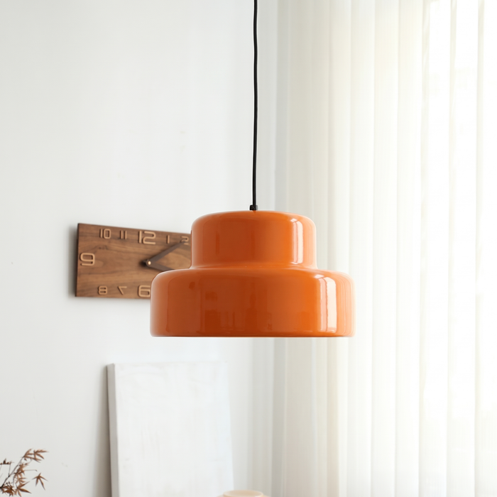 Sunna orange pendant light hanging beside a pleated white curtain and a small wooden wall clock in a bright Bauhaus-style hallway